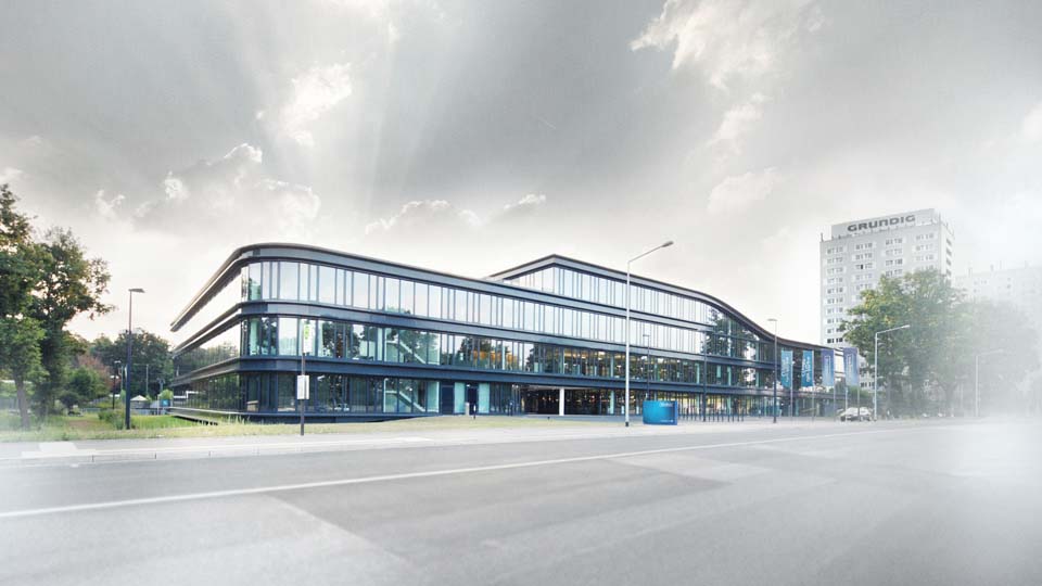 Das Gebäude der TeamBank in der Außenansicht. Wolkenverhangener Himmel. Drei Stockwerke, Glasfront, TeamBank Schild vor dem Eingang. Grünflächen außen herum.