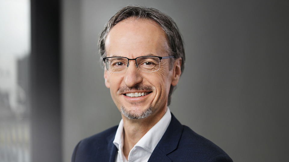 Portrait Bild von Reinhold Rehbichler mit dunklen Haaren, Bart, Brille und im Anzug
