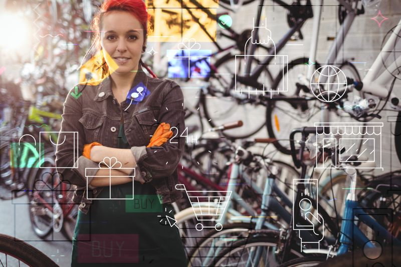 Frau von Fahrrad-Reparaturservice steht vor vielen Fahrrädern.